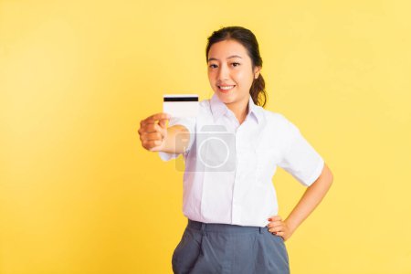 Téléchargez les photos : Smiling high school girl holding blank card on isolated background - en image libre de droit