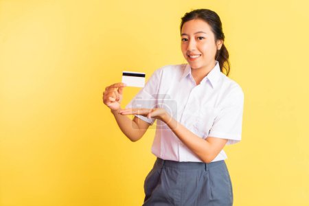 Téléchargez les photos : High school girl with hand gesture presenting something while holding blank card on isolated background - en image libre de droit