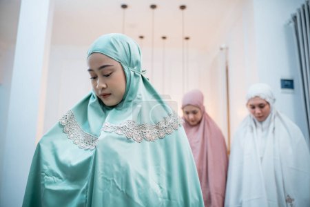 Téléchargez les photos : Femmes musulmanes portant des vêtements musulmans avec hijab priant dans la congrégation dans la salle de prière - en image libre de droit