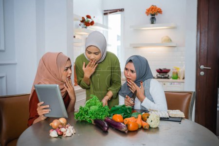 Téléchargez les photos : Portrait of Hijab women and friends using tablet smartphone and shocked - en image libre de droit