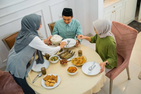 Téléchargez les photos : Asiatique musulman personnes ayant dîner pause jeûner ensemble à la maison pendant ramadan - en image libre de droit