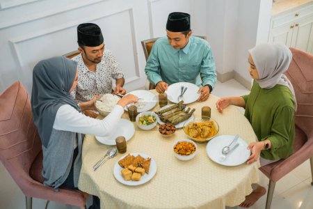 Téléchargez les photos : Asiatique musulman personnes ayant dîner pause jeûner ensemble à la maison pendant ramadan - en image libre de droit