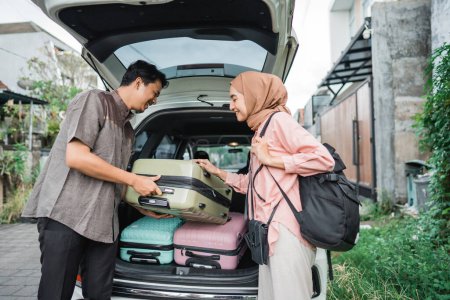 muslim couple packing suitcase in the car trunk for eid mubarak holiday