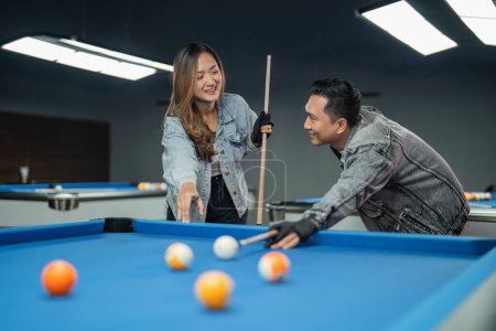 Photo for Couple of pool players looking each other while playing billiard together at billiard studio - Royalty Free Image