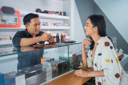 Photo for Male vape seller helping the female customer to refill the e liquid at vape store - Royalty Free Image