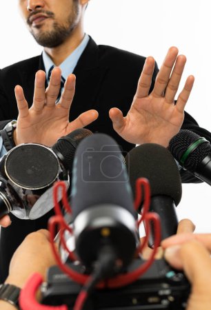Téléchargez les photos : Beaucoup de microphone pointé sur un homme adulte en chemise bleue et costume noir pendant la convergence de la presse - en image libre de droit