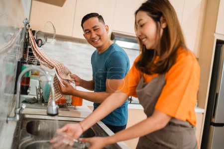 Foto de Asiático pareja lavavajillas vajilla juntos en la cocina - Imagen libre de derechos