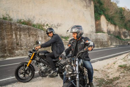 Téléchargez les photos : Aventure amusante des cavaliers indonésiens conduisant une moto autour de la campagne - en image libre de droit