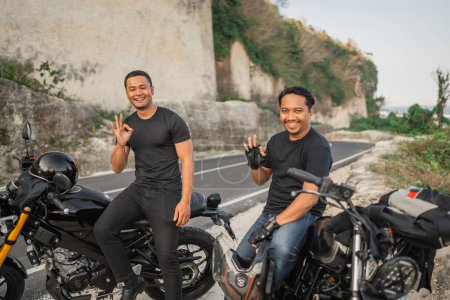 Téléchargez les photos : Asiatique les hommes assis sur moto avec ok main geste - en image libre de droit