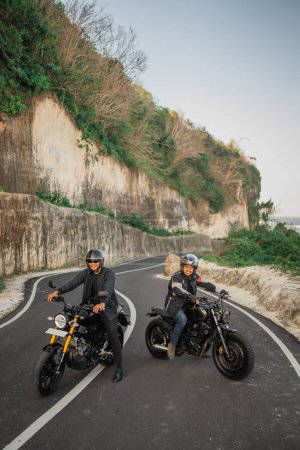 Téléchargez les photos : Potrait d'homme indonésien vêtu d'une veste et d'un casque assis sur une moto - en image libre de droit