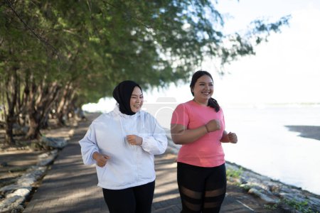 Téléchargez les photos : Plus les femmes de taille jogging ensemble à l'extérieur, concept de mode de vie sain - en image libre de droit