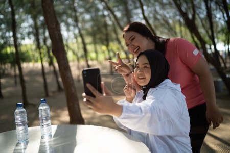 Téléchargez les photos : Heureux asiatique femmes prendre photo ensemble après exercice - en image libre de droit