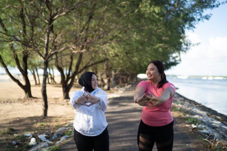 Téléchargez les photos : Deux asiatique femmes échauffement jusqu 'ensemble avant courir - en image libre de droit