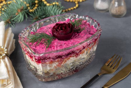 Photo for Traditional Russian holiday salad Herring under a fur coat decorated rose from beet in transparent salad bowl - Royalty Free Image