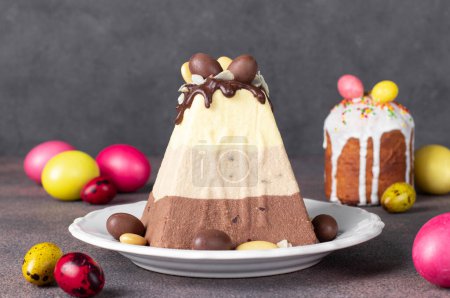 Traditional Easter curd dessert made of three types of chocolate - white, milk and dark and as well Easter cake and colorfull eggs