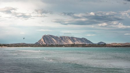 Photo for Mountain of island Tavolara in Sadinia Italy at San Teodoro sand beach with turquoise sea water, kite surfer on water - Royalty Free Image