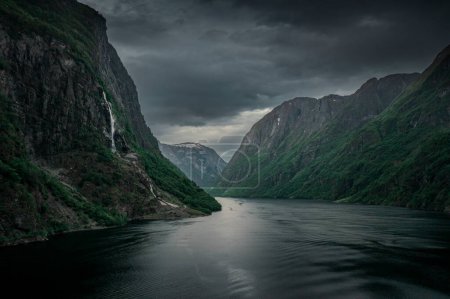 Téléchargez les photos : Moody fjord with mountains and waterfall of Aurlandsfjord at Gudvangen in Norway, dark clouds in the sky, from above - en image libre de droit