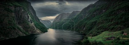 Téléchargez les photos : Moody fjord with mountains and waterfall of Aurlandsfjord at Gudvangen in Norway, dark clouds in the sky, from above - en image libre de droit