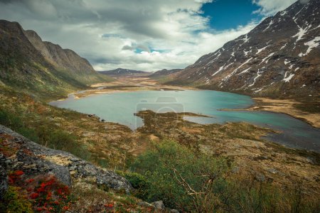 Foto de Turquoise lake surrounded by mountain landscape at Knutshoe summit in Jotunheimen National Park in Norway - Imagen libre de derechos
