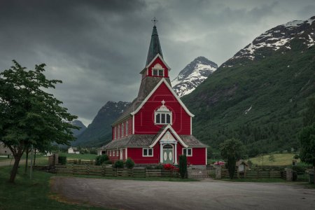 Téléchargez les photos : Red wooden church of Olden in the Nordfjord fjord in summer in Norway, moody atmosphere in the mountains and sky - en image libre de droit