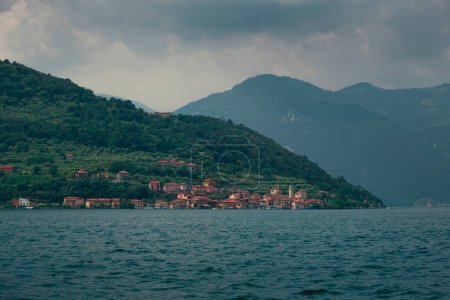 Téléchargez les photos : Village Carzano sur l'île Monte Isola du lac d'Iseo en Italie, après-midi soleil avec nuages dans le ciel. Juin 2023 - en image libre de droit