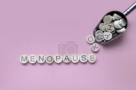 Foto de El alfabeto forma una palabra menopausia. Salud y concepto médico para las mujeres. Fondo rosa. - Imagen libre de derechos