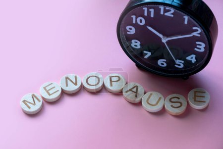 Photo for Alphabet form a word menopause over a clock. Healthcare and medical concept for women. Pink background - Royalty Free Image
