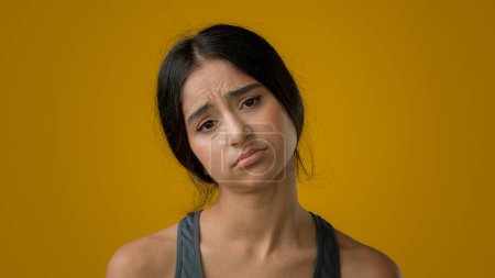 Photo for Sad upset worried Indian woman girl in yellow studio background dissatisfied female face with bad body measuring result unhappy weight size shape fitness failure waist fat diet unhealthy depression - Royalty Free Image