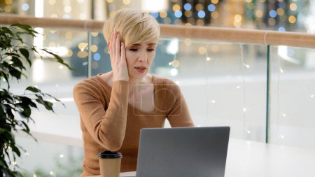 Photo for Caucasian middle aged mature 40s business woman with laptop working problems with payment computer breakdown error losing feeling frustrated bad news quitting letter low battery feeling stress trouble - Royalty Free Image