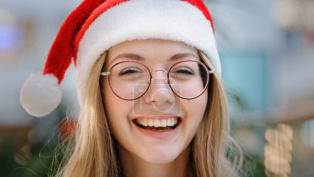 Photo for Close up portrait funny smiling toothy laughing happy Caucasian woman girl lady wearing Santa Claus Christmas hat and eyeglass looking at camera smile laugh headshot female face New Year celebration - Royalty Free Image