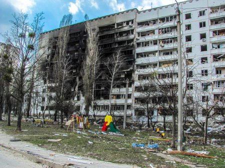 Foto de Kharkiv, Kharkov, Ucrania - 05.07.2022: La invasión rusa de la guerra militar en Ucrania destruyó el edificio con un patio de recreo quemado después de bombardear la bomba bombardeo aéreo ataque con cohetes bombardeo de la ciudad civil ucraniana - Imagen libre de derechos
