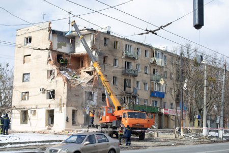 Foto de Kharkiv, Kharkov, Ucrania - 05.07.2022: Agresión rusa en la ciudad ucraniana vista exterior desmantelamiento edificio residencial destruido bombardeado casa estrellada en la carretera calle después de la invasión militar - Imagen libre de derechos