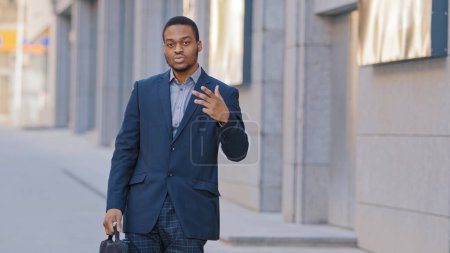 Photo for Confident African American serious man employee entrepreneur businessman ethnic male guy worker manager posing funny dancing looking at camera in city outdoors proud with business success triumph - Royalty Free Image