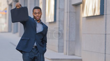Photo for Confident proud male African American businessman excited man worker entrepreneur at city on street outdoors holding showing briefcase looking at camera enjoy job offer opportunity career success - Royalty Free Image