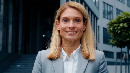 Foto de Female business portrait happy young smiling woman standing near office building looking at camera successful motivated businesswoman leader boss corporate employee satisfied customer posing outdoors - Imagen libre de derechos