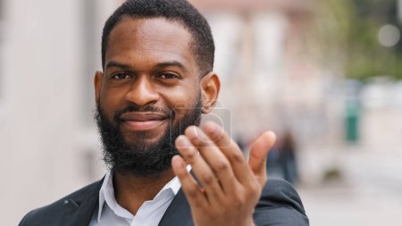 Téléchargez les photos : Headshot ethnic African American man entrepreneur employer male HR manager CEO businessman invite to come welcoming hand gesture inviting candidate at job interview invitation sign in city outdoors - en image libre de droit
