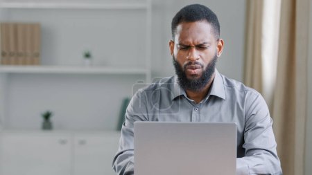 Photo for Confused puzzled African American ethnic bearded man reading bad news bank notice work with online project has difficult task office worker businessman with laptop computer failure business problem - Royalty Free Image