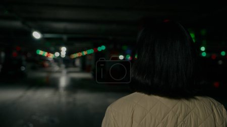 Photo for Back rear view from behind brunette with short hair woman walk at parking lot. Elegance lady girl customer client female businesswoman walking at mall underground in darkness moving hurry to meeting - Royalty Free Image