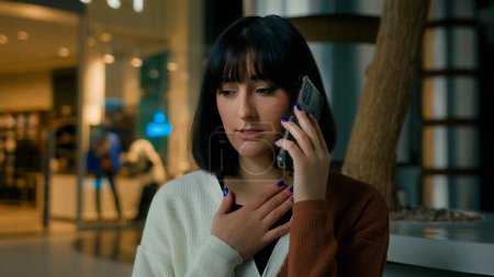 Foto de Worried upset woman indoors answer call talking phone disappointed shocked with smartphone conversation business problem lady speaking worry dissatisfied stressed female mobile talk trouble bad news - Imagen libre de derechos