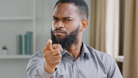 Foto de Portrait in office mad angry aggressive bearded African American businessman professional manager employer man office worker furious pointing finger at camera threat gesture warning with hand hey you - Imagen libre de derechos