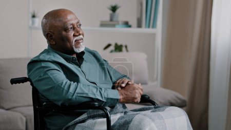 Photo for Pensive dreaming calm alone elderly patient. old African bald man with gray beard senior mature grandpa sit on wheelchair at home looking away dreams thinking ponders deep in memories Alzheimer. High - Royalty Free Image