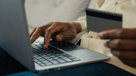 Foto de Close-up male hands man customer buyer holding credit card making purchase paying using banking electronic computer application in online store on laptop remote pay for delivery makes secure payment - Imagen libre de derechos