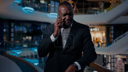 Photo for Sad ethnic middle-aged man African American entrepreneur answer phone call talking smartphone talk cellphone listen bad news frustrated loose money lost job notification failure stressed businessman - Royalty Free Image