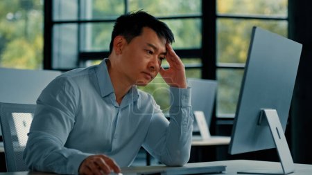 Photo for Asian businessman korean man work online at workplace difficult hard job get incorrect error in computer failure business problem. Upset anxious male disappointed about mistake bad internet in office - Royalty Free Image