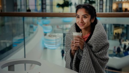 Téléchargez les photos : Heureux arabe reposante hispanique ethnique jeune femme adolescente étudiante s'asseoir au café restaurant boisson caféine chaude porte couverture chaude boire arôme café tisane relaxant thé concept - en image libre de droit