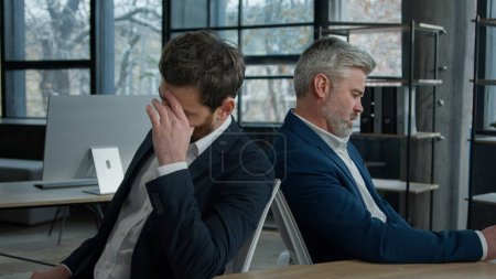 Téléchargez les photos : Bouleversé choqué caucasiens hommes d'affaires partenaires employés assis dans le bureau frustré par la faillite d'entreprise penser à problème financier entrepreneurs déprimés collègues ont du mal à se sentir inquiet - en image libre de droit