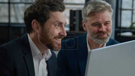Photo for Close-up two surprised caucasian men different ages businessmen colleagues look in surprise at computer screen amazed corporate employees business partners receive good news win satisfied achievement - Royalty Free Image