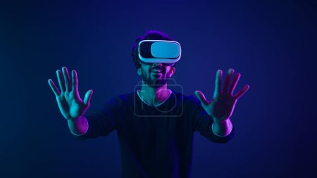 Metaverse virtual reality cyberspace world man play game playing guy meta universe experience digital technology with VR goggles helmet cyber gamer neon ultraviolet futuristic space cyberpunk gaming