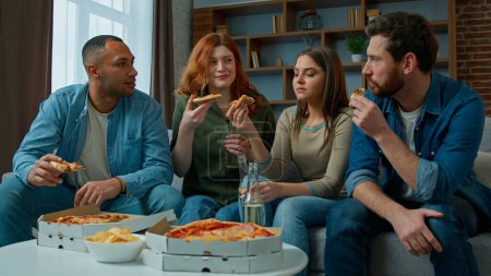 Foto de Friends drinkers ethnic caucasian african american women and men drinking beer celebrate at home festive table eating pizza multiracial diverse people talking fun hangout party corporate dinner lunch - Imagen libre de derechos