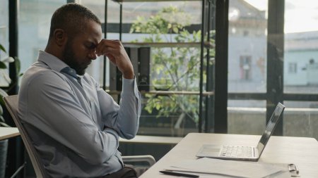 Téléchargez les photos : Homme d'affaires mûr afro-américain surmené travaillant ordinateur portable au bureau souffrent de fatigue oculaire épuisé malade fatigué homme d'affaires d'âge moyen se sentent douleur gêne vue maux de tête santé migraine - en image libre de droit